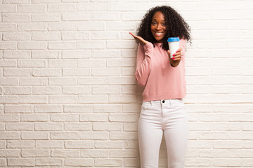 Young black woman surprised and shocked, looking with wide eyes, excited by an offer or by a new job, win concept