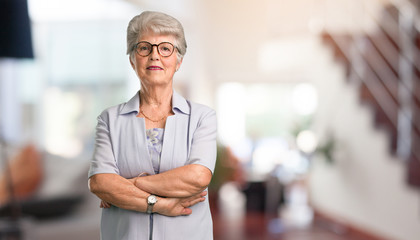 Beautiful senior woman crossing his arms, smiling and happy, being confident and friendly at home.