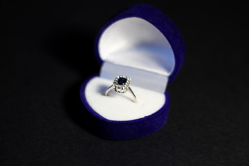 a close up on the elegant, white gold ring in the ring box, black background, free copy space