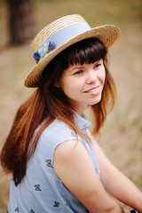 Young woman in straw boater hat smile in summer outdoors