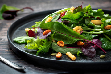 Salad from different types of lettuce, peanuts and seeds.