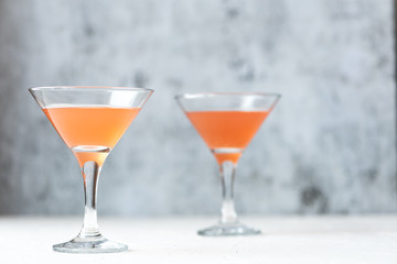 Cocktails in a martini glass on a gray background.