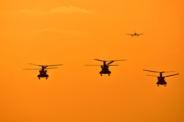 Fototapeta na wymiar 夕焼け空を飛行している3機のヘリコプター 　　背景に航空機　　Sunset The three helicopters flying in the sky Aircraft in the background　Radiates the glow of the sunset Flying happiness Aircraft image carrying good luck　