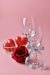 Empty wine glass, with rose at the bottom on pink background. Concept of Valentine's Day, pop art contemporary, celebrate.