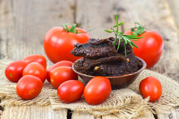 fresh and dried tomatoes on wooden background