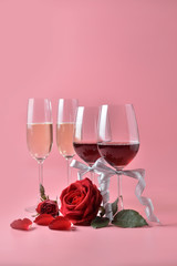 Red wine and champagne in glass, with rose at the bottom on pink background. Concept of Valentine's Day, pop art contemporary, celebrate.