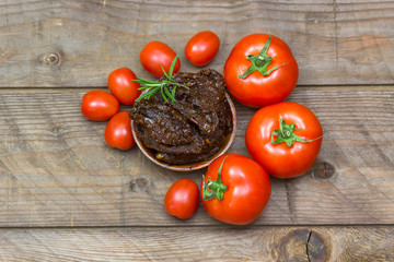 fresh and dried tomatoes on wooden background