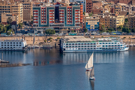 12.11.2018 Aswan, Egypt, A boat felucca sailing along a river of nilies on a sunny day against a city background