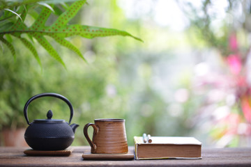Black vintage teapot and clay cup at outside 
