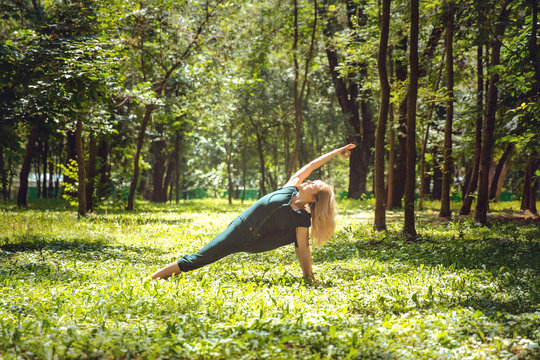 Utthita parsvakonasana. Yoga asanas in nature. Yoga poses everyday. Practicing young woman. Yoga in the park