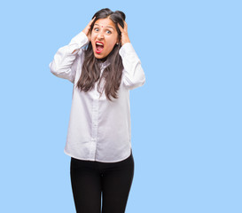 Portrait of a young indian woman frustrated and desperate, angry and sad with hands on head