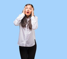 Fototapeta premium Portrait of a young indian woman frustrated and desperate, angry and sad with hands on head