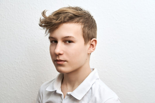 Portrait of a teenage boy blond on a white background close-up