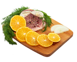 meat steak on a board with onion greens and lemon