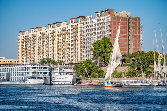12.11.2018 Aswan, Egypt, A boat felucca sailing along a river of nilies on a sunny day against a city background