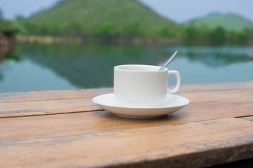 Coffee cup on lake side table.