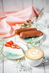 delicious cup of cappuccino with strawberry cheesecake