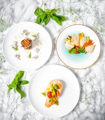 delicious dinner of salmon steak, grilled beef medallions and chicken fillet with vegetables