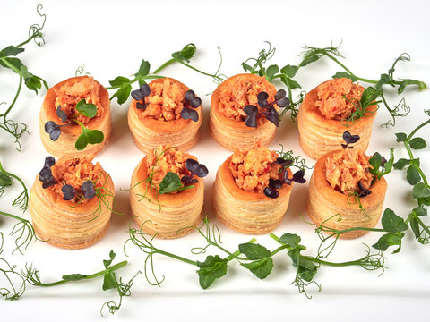 Puff pastries with a spicy, chunky salmon filling, garnished with pea shoots