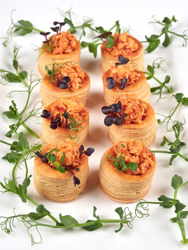 Puff pastries with a spicy, chunky salmon filling, garnished with pea shoots