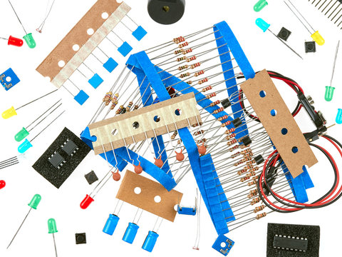 A selection of active and passive electronics components: buttons, LEDs, resistors, capacitors, buzzer, connecting wires, transistors and integrated circuits.