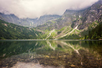 Fototapeta na wymiar Amazing nature, alpine lake in the mountains, summer landscape with cloudy sky and reflection in crystal clear water, Morske Oko (Eye of the Sea), Tatra Mountains, Zakopane, Poland