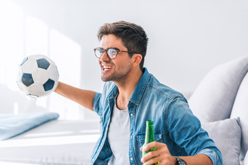 Fanatic football fan man watching soccer game on tv celebrating
