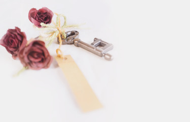 Old key and paper tag and dried rose flower head .Valentine's day concept background.