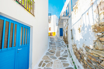 Narrow street with traditional rustic houses in the village, Island of Paros, Greece
