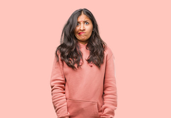 Fototapeta premium Portrait of fitness young indian woman worried and overwhelmed, forgetful, realize something, expression of shock at having made a mistake