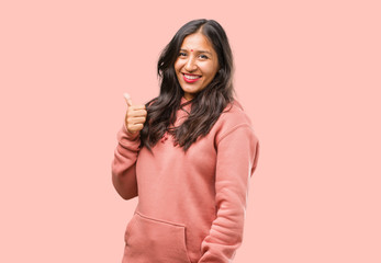 Portrait of fitness young indian woman cheerful and excited, smiling and raising her thumb up, concept of success and approval, ok gesture