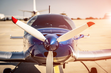 Fototapeta na wymiar Shiny blue sport plane at the airport sunshine runway