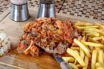 Tender grilled porterhouse or t-bone steak served with crisp golden French fries and fresh green...