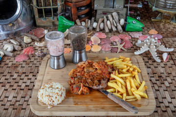Tender grilled porterhouse or t-bone steak served with crisp golden French fries and fresh green...
