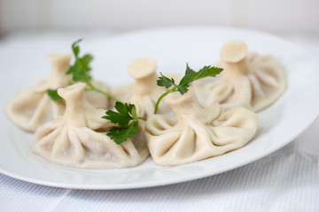 international fusion cuisine khinkali, a beautiful dish on a white plate decorated with herbs and...