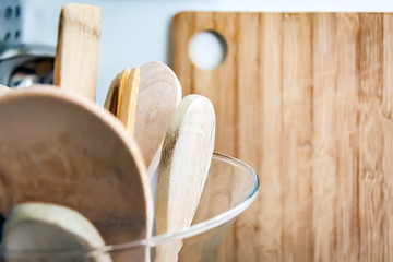 Wooden kitchen utensils in a glass container.