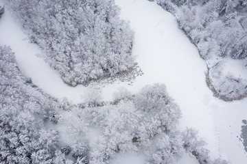Aerial view of winter beautiful landscape with trees covered with hoarfrost and snow. Winter scenery from above. Landscape photo captured with drone.