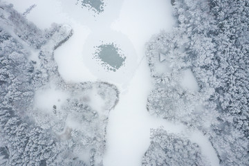 Aerial view of winter beautiful landscape with trees covered with hoarfrost and snow. Winter scenery from above. Landscape photo captured with drone.