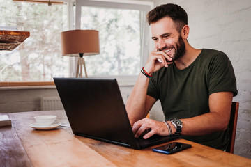 Young casual man working on a laptop