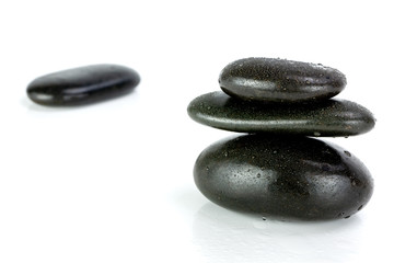 Stack of black pebbles on white background