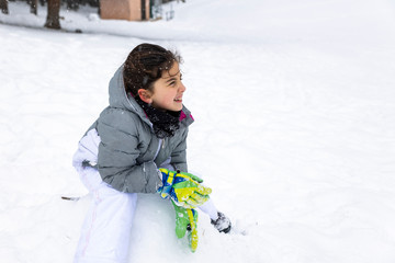 Fototapeta na wymiar Little girl seated on a snowy field