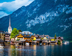 Fototapeta na wymiar evening scenery of beautiful Hallstatt at the wide lake on the background of rocky forested mountains