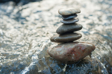 Fototapeta na wymiar Closeup of stone balance on rock in the river