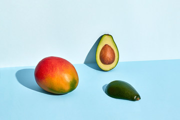 Avocado and mango fruits on blue background