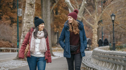 Two young woman on a trip to New York take a relaxing walk in Central Park