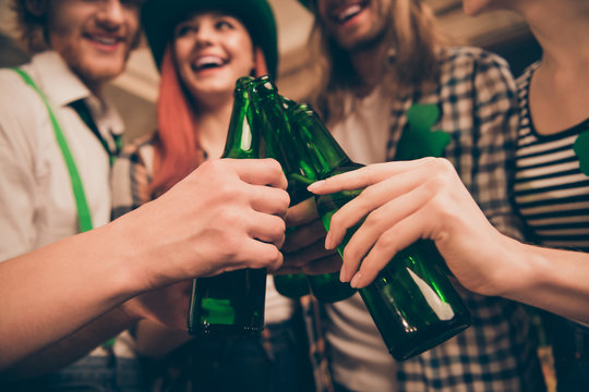 Cropped close up photo festive gathering company hands raise beer bottles toothy smiling laugh laughter bar pub celebrating funny funky carefree make take pictures every year tradition