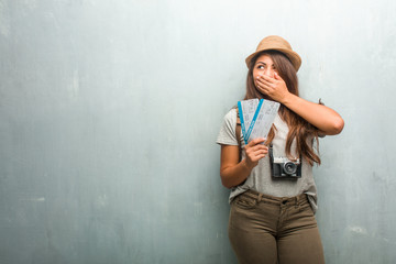Portrait of young traveler latin woman against a wall covering mouth, symbol of silence and...