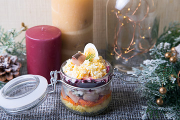 Herring under a Fur Coat. Traditional Russian multilayered salad from herring, beets, potatoes, carrots and eggs. Close-up, selective focus.