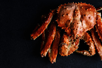Big whole alaskan crab on dark concrete background with copy space