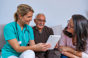 Positive senior couple with their caregiver in nursing home for elderly